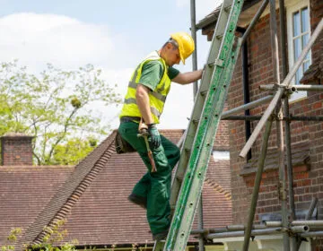 Roofer climbing ladder in Barnet