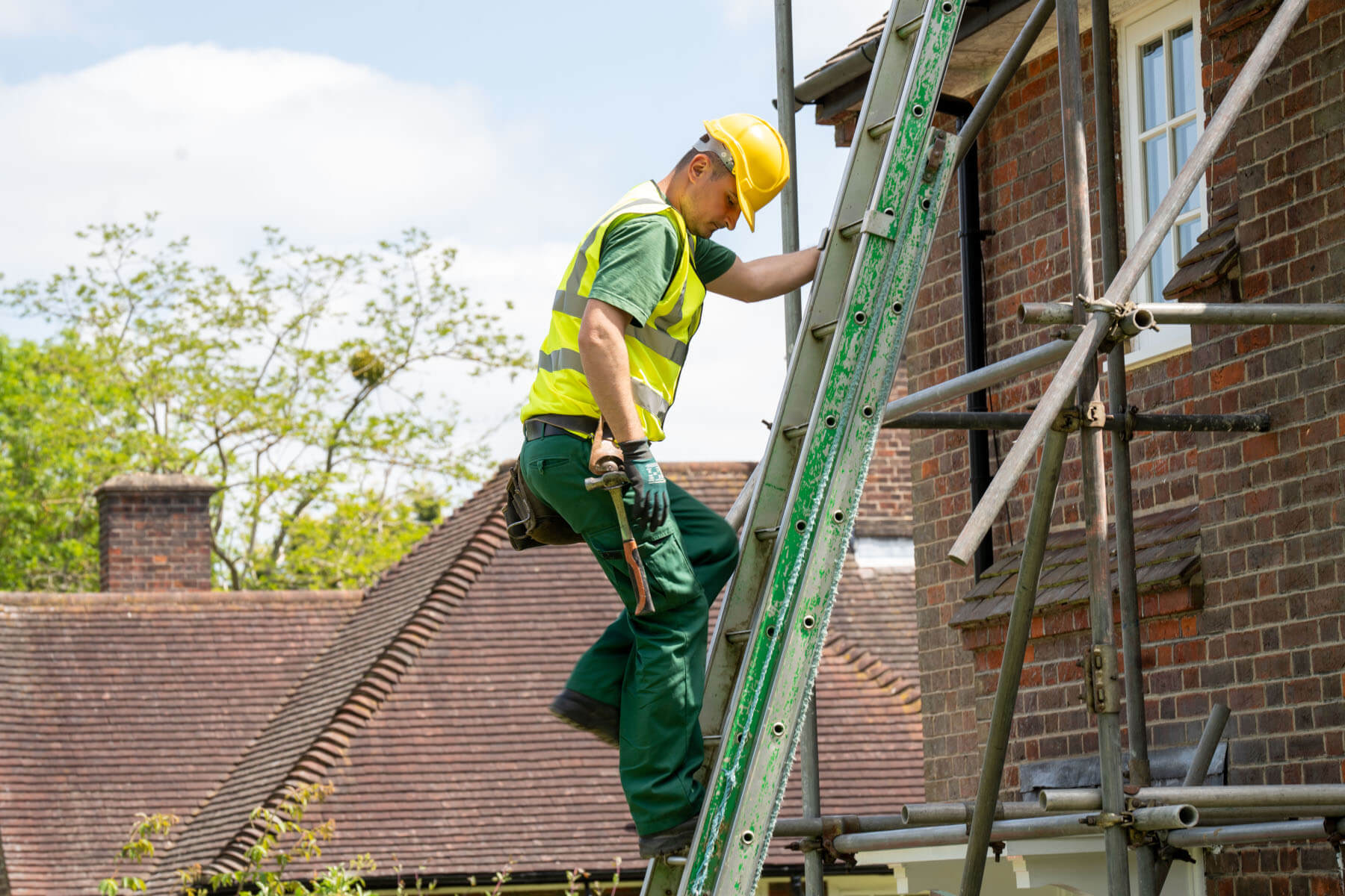 Roofer climbing ladder in Barnet